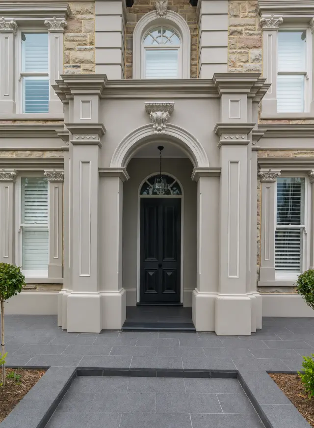 Custom timber windows and mouldings fitted to a detailed stone façade.