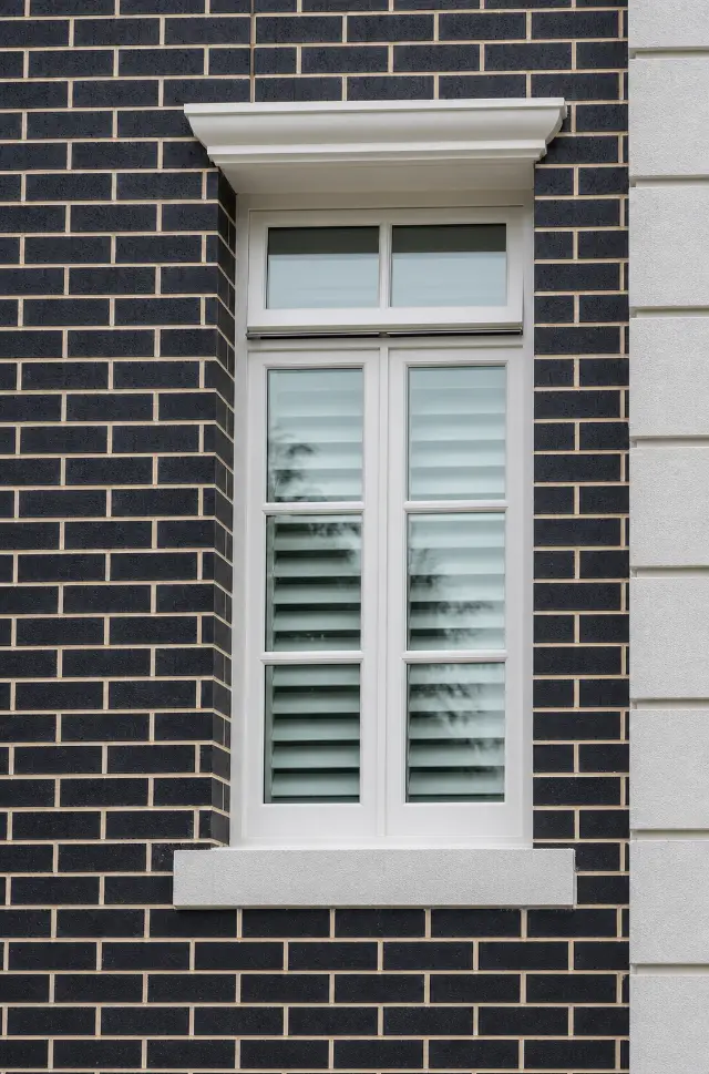 A tall custom timber window set within contrasting brickwork.